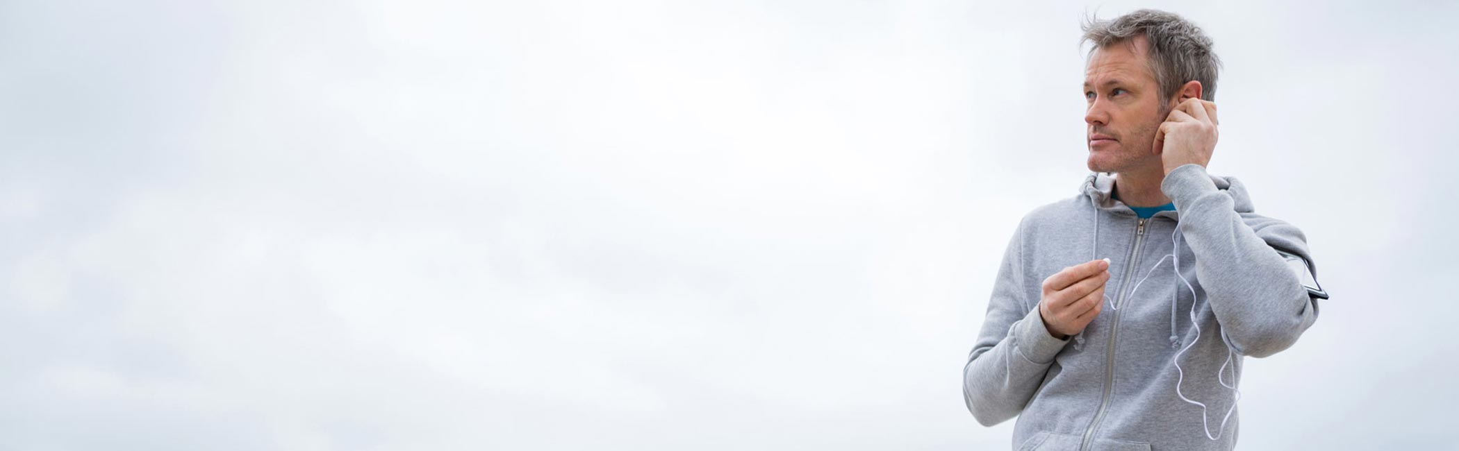 En mand går i naturen og lytter til musik.