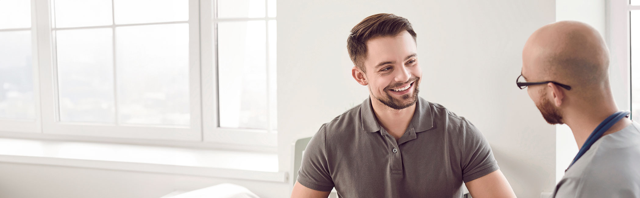 Læge taler med patient ved en konsultation.